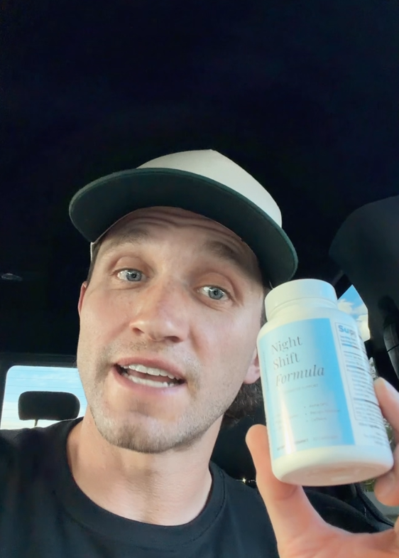 Man holding a bottle of Night Shift Formula cognitive support supplement